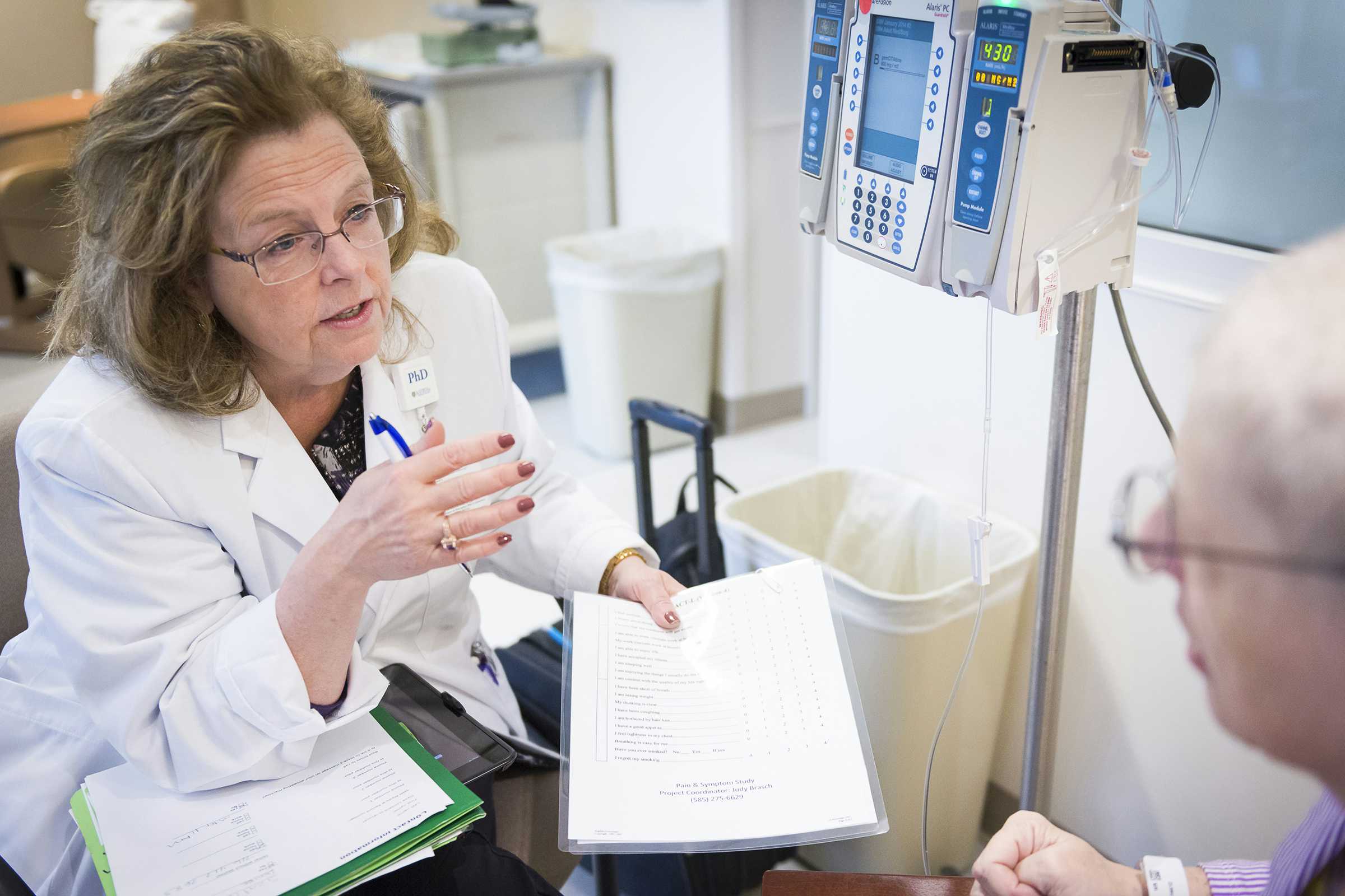 Nurse researcher talking to a cancer patient.