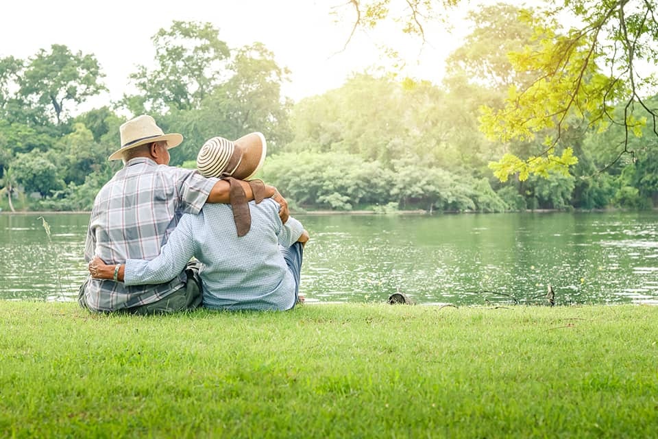Image of two older adults outside in a park.