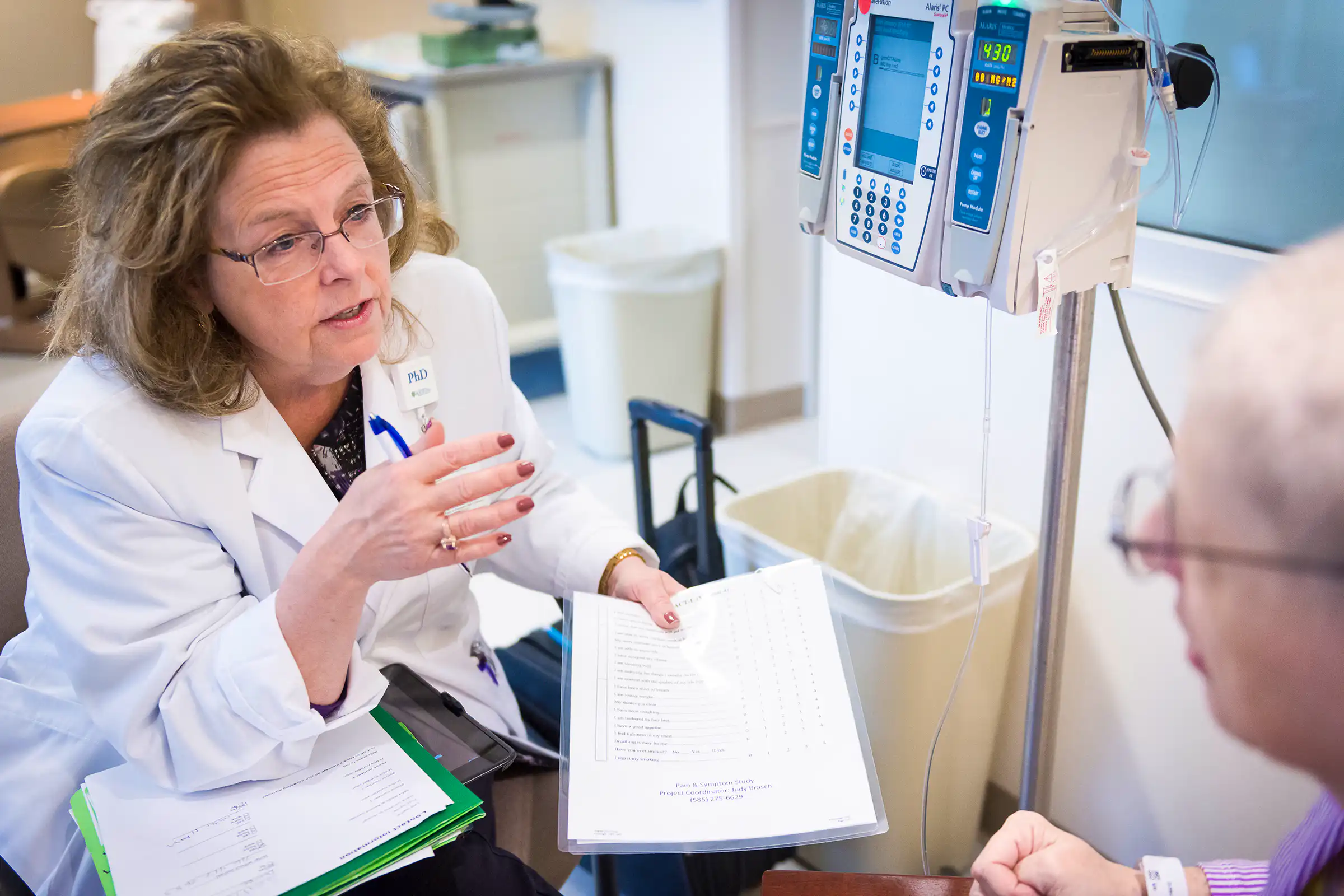 Nurse researcher talking to a cancer patient.