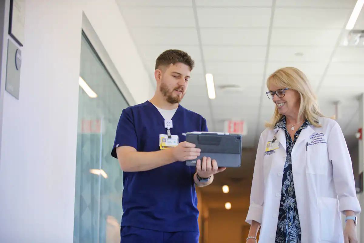 Master's student conferring with faculty instructor on iPad device