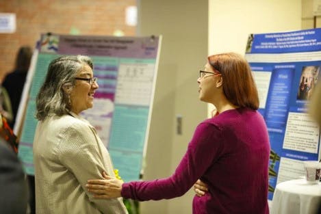 Faculty member and student discussing research on a poster abstract