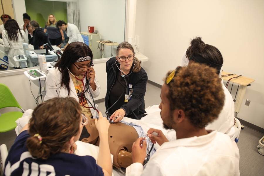 Assistant Professor Dee Dee Rutigliano leads an exercise with East High scholars in one of the School of Nursing's simulation suites.