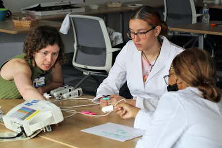 Stephanie Schechter shows students how to use a fingertip pulse oximeter.