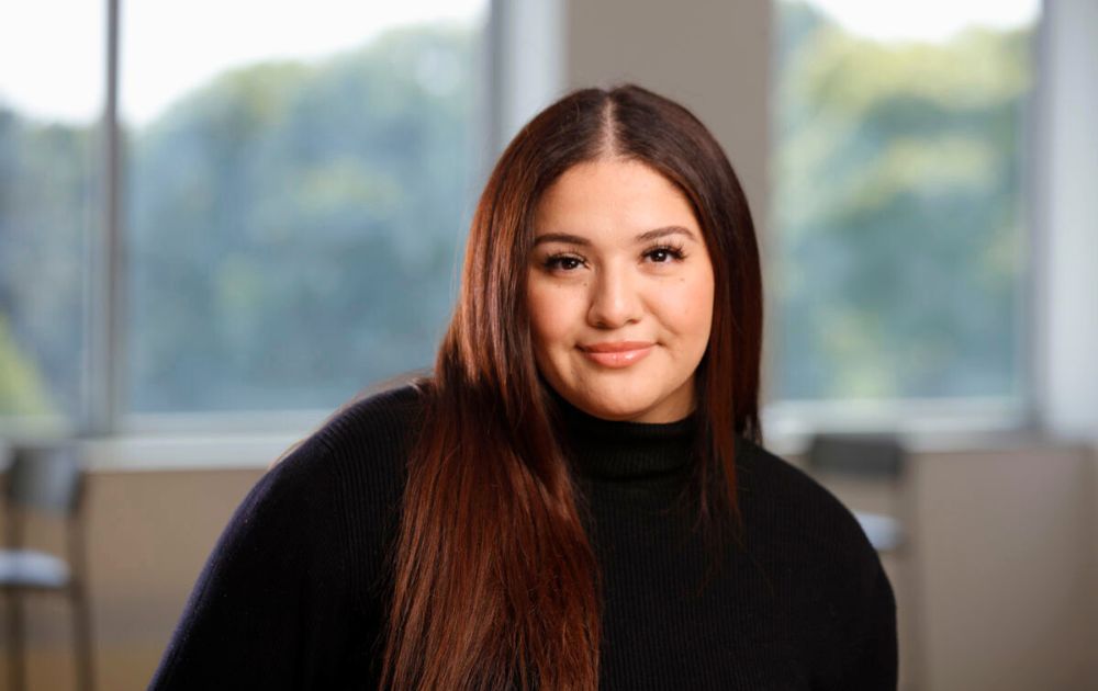 Portrait of Arline smiling and wearing a black sweater.