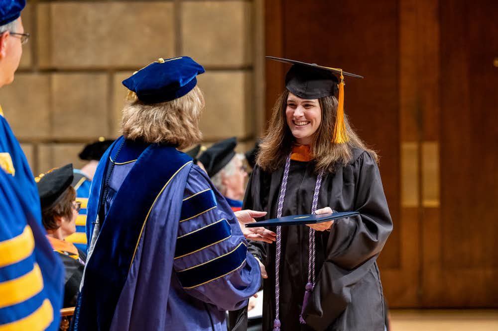 Pediatric NP graduate Amy Miller receives her diploma from Dean Lisa Kitko.