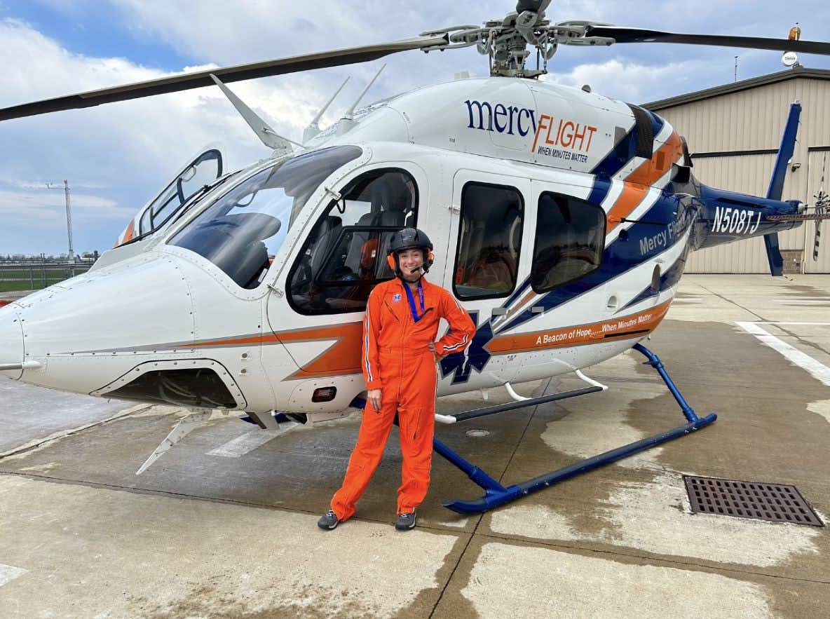 Samantha Loper in front of a Mercy Flight helicopter