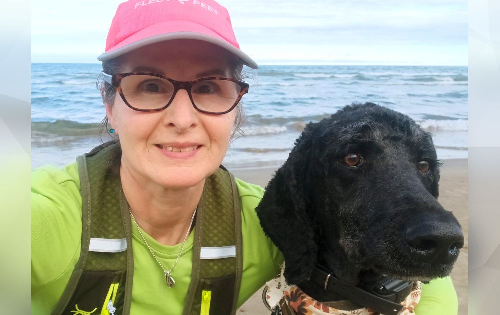 Photo of Kimberlee and her dog along a lake.