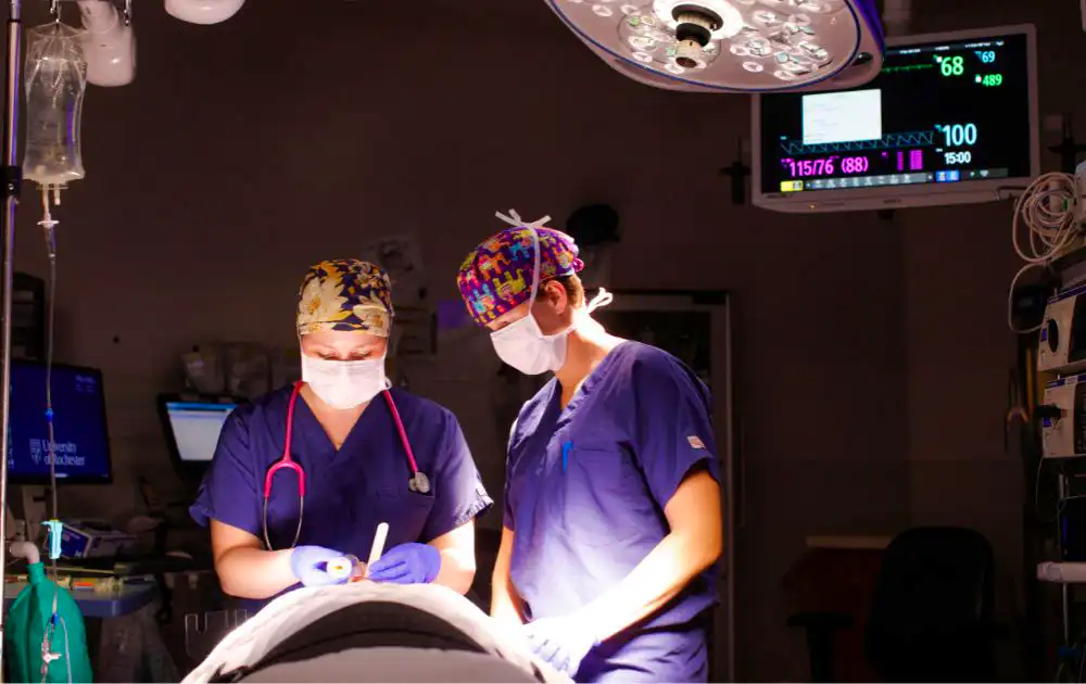 Photo shows two nurse anesthetists working in an operating room.
