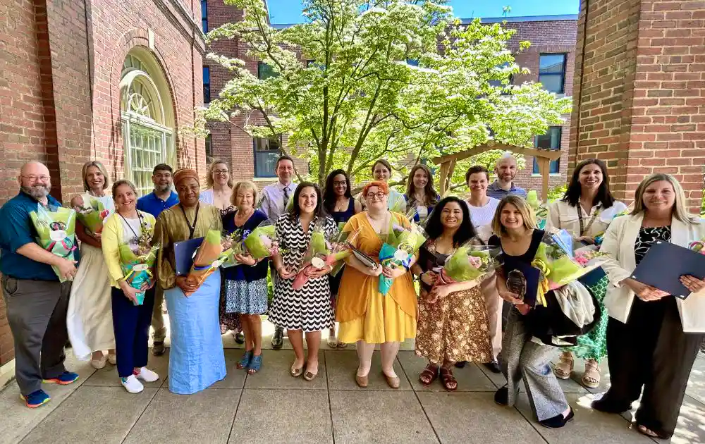 Group photo of award recipients holding bouquets of flowers. 