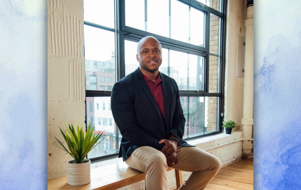 Headshot of Orlando Harris over a white and blue watercolor background