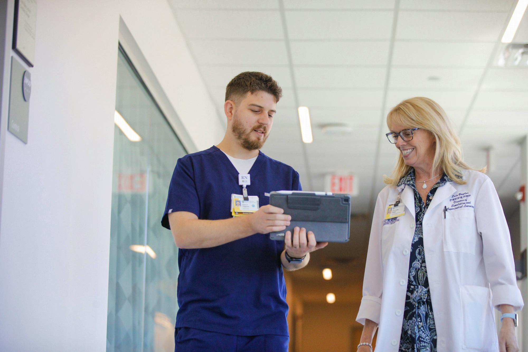 Faculty member walking with a nursing student