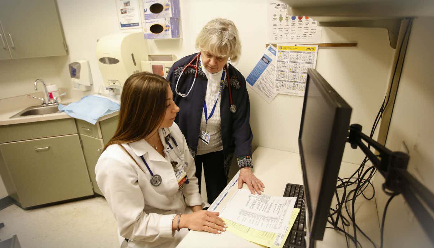 Senior nurse teaching a nursing student in a clinical room