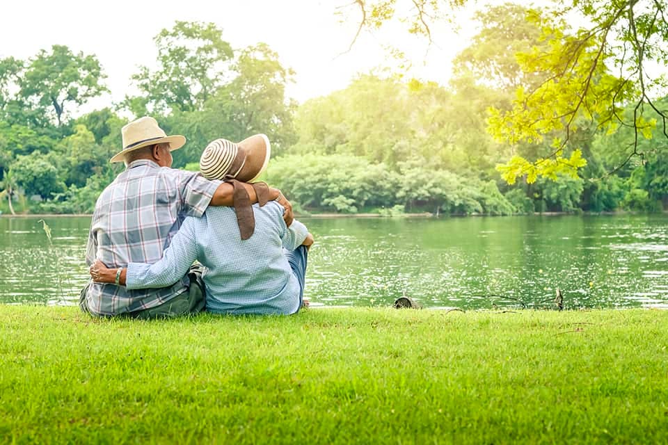 Image of two older adults outside in a park.