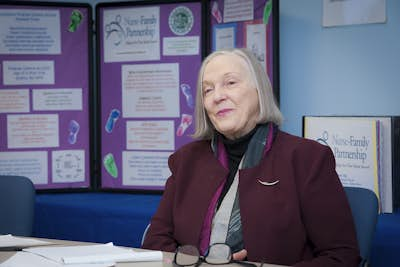 Photo of Harriet Kitzman with a research poster behind her