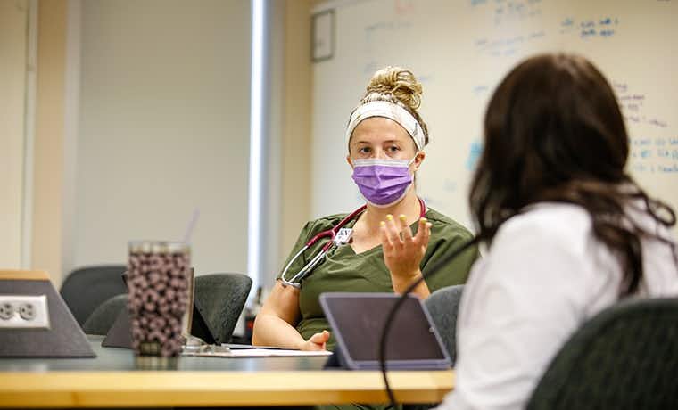 Nursing student with mask at table